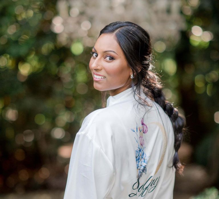 Bride looks over her shoulder as she wears white personalised dressing gown