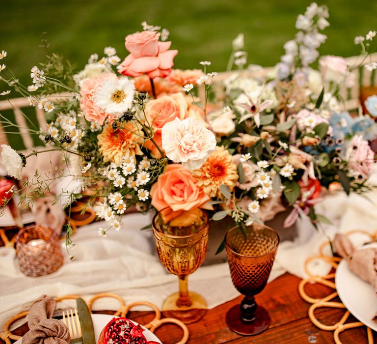 Pastel florals, amber glassware and boho decor for rustic outdoor wedding breakfast 