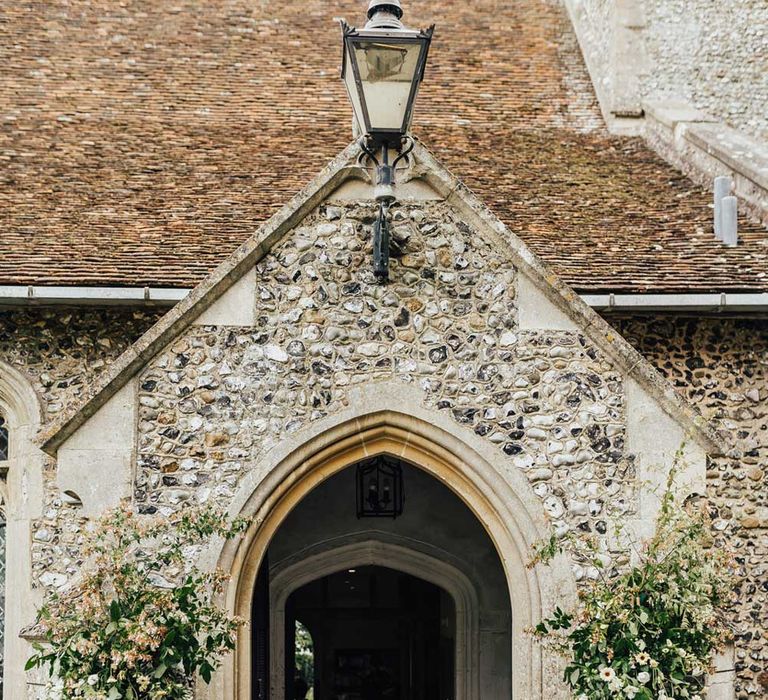 Exterior of church with floral installations for church wedding ceremony