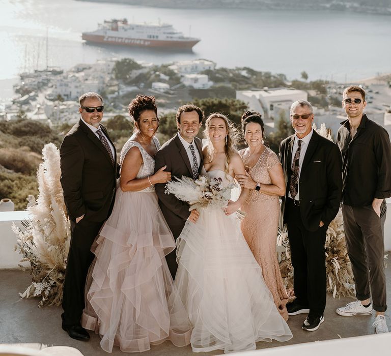 Bride & groom stand with their wedding party outdoors in Greece 