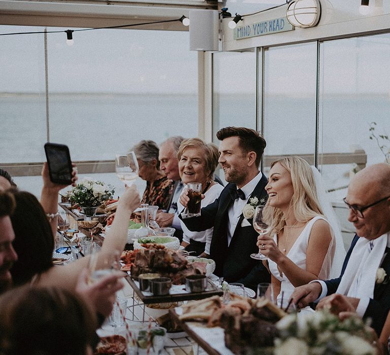 Wedding guests toast at intimate restaurant wedding