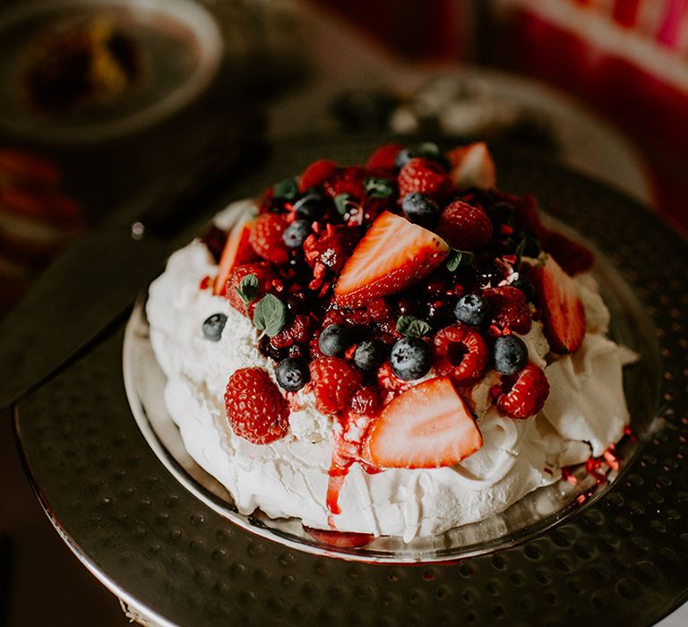 Meringue pavlova topped with straw blue and rasp berries 