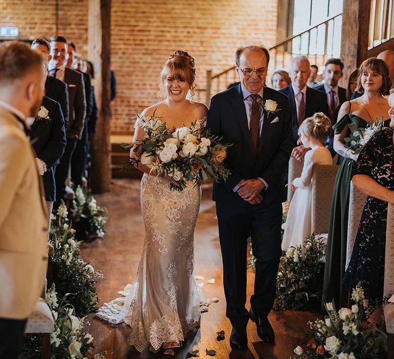 Father of the bride walks the bride down the aisle in barn style wedding at Cooling Castle Barn