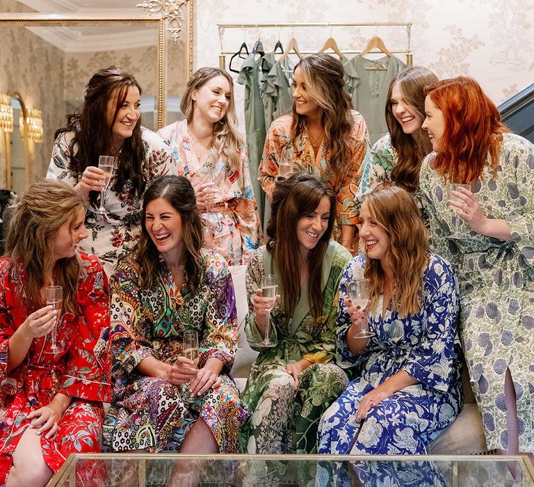 Bride with bridesmaids in colourful and funk patterned satin robes as they get ready for the big day