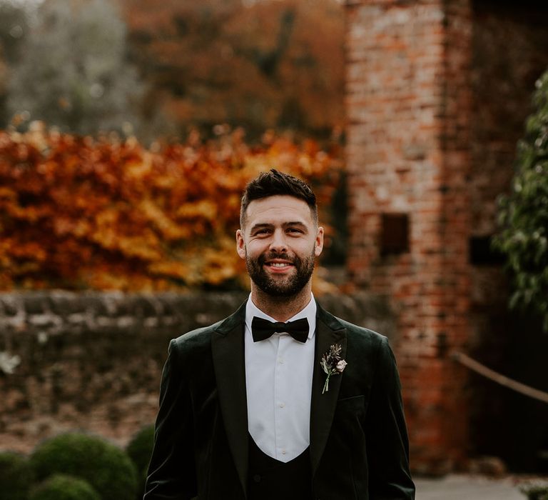 Groom with beard and spiked hair wearing three piece black tie for his winter wedding