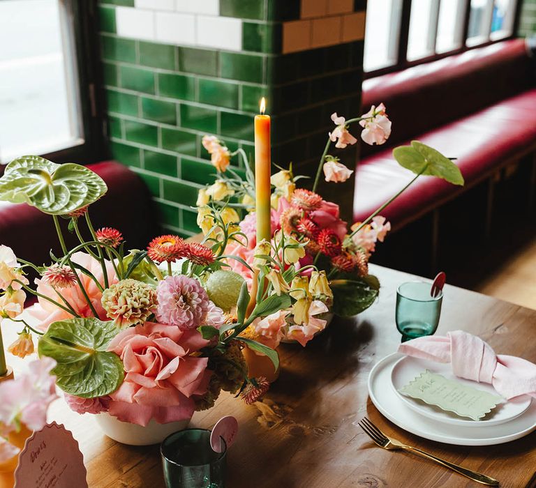 wedding reception place settings and table decor with zesty yellow, green and pink flowers, ombre candles and on the day wedding stationery 