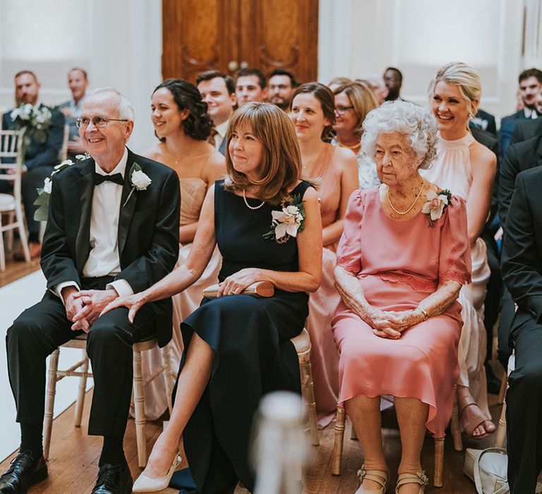 Family members and wedding guests watch the wedding ceremony 