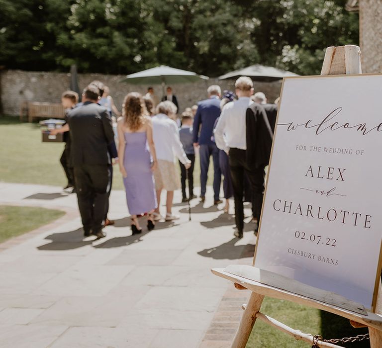 White wedding welcome sign on a wooden easel for classic barn wedding 