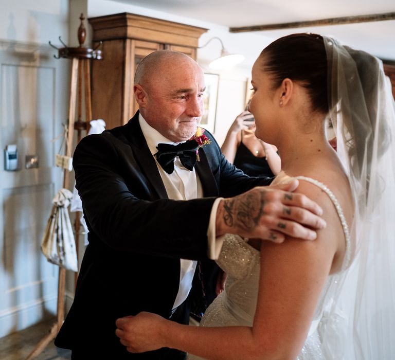 Bride's father in black tie sees his daughter for the first time on the morning of her wedding day