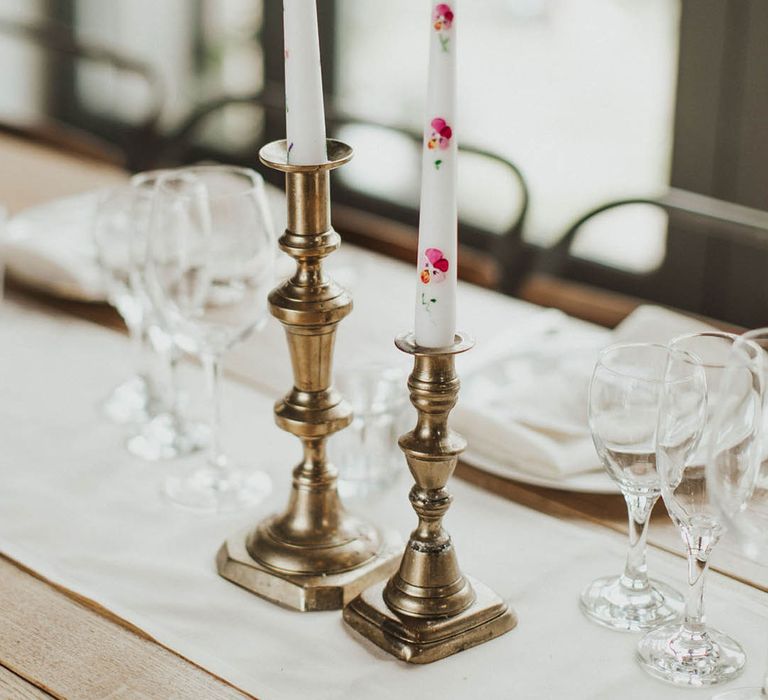 Handpainted flowers on white taper candles in gold candleholders for the botanical woodland wedding 