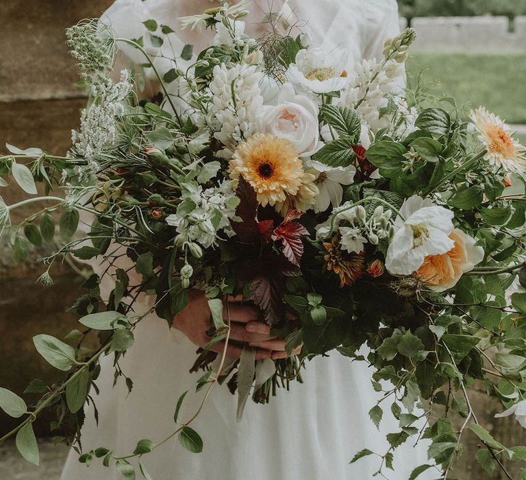 Oversized wedding bouquet with foliage and yellow and white flowers 