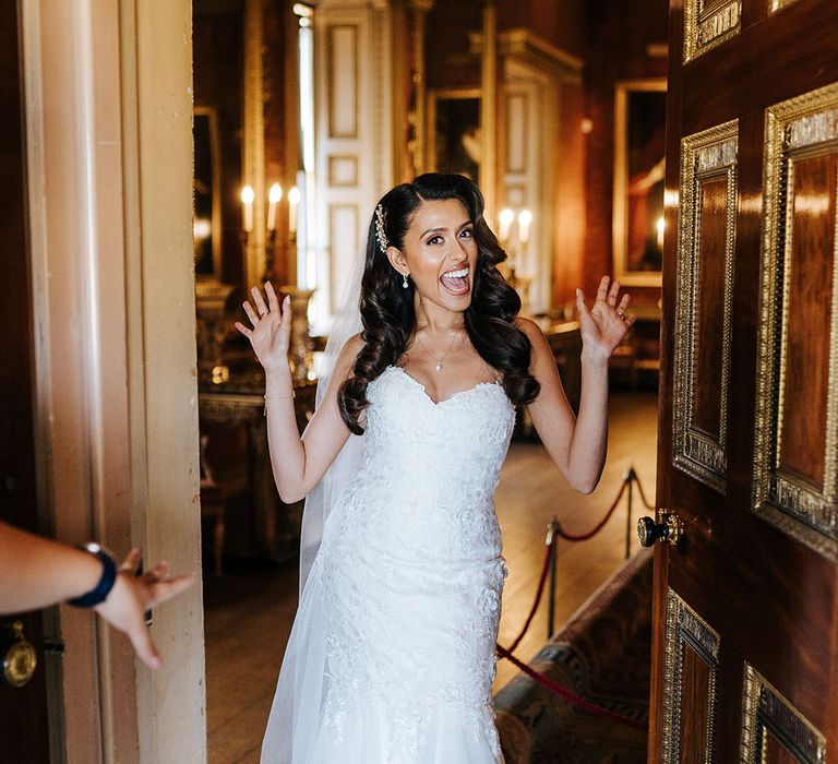 Indian bride wears her hair in loose curls complete with embellished hair accessory and lace sweetheart neckline wedding dress with mermaid train