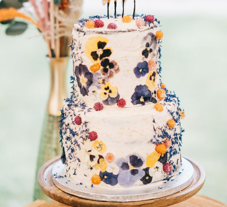 Rustic two tier wedding cake with edible flowers and two fox cake toppers