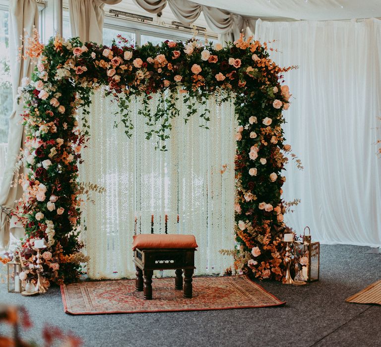 Floral archway with Autumnal colour scheme at boho styled wedding day