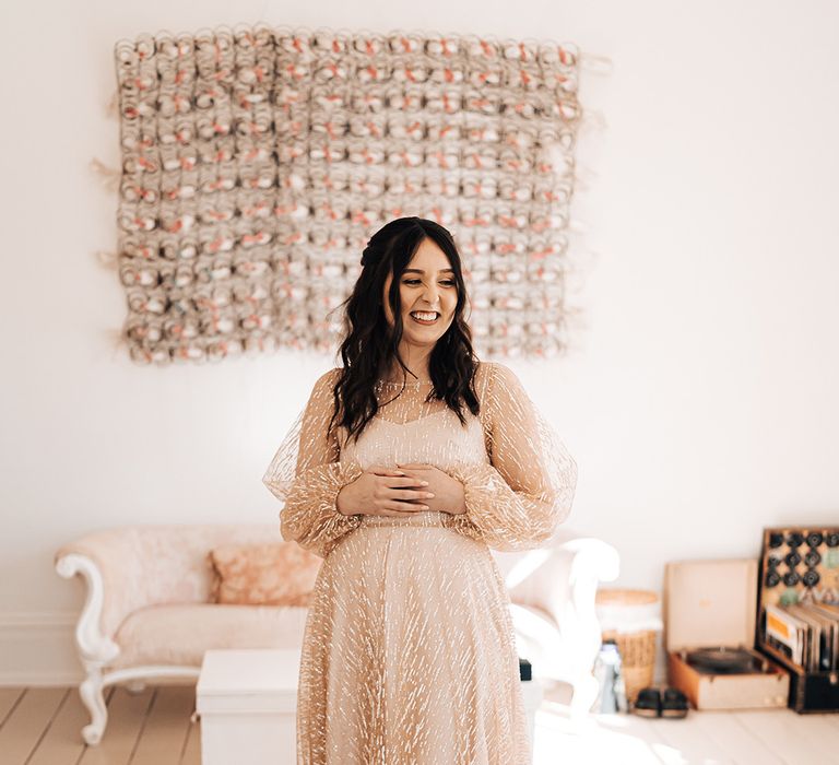 Bride wears full long sleeve sheer gold wedding dress and gold peep toe heeled shoes