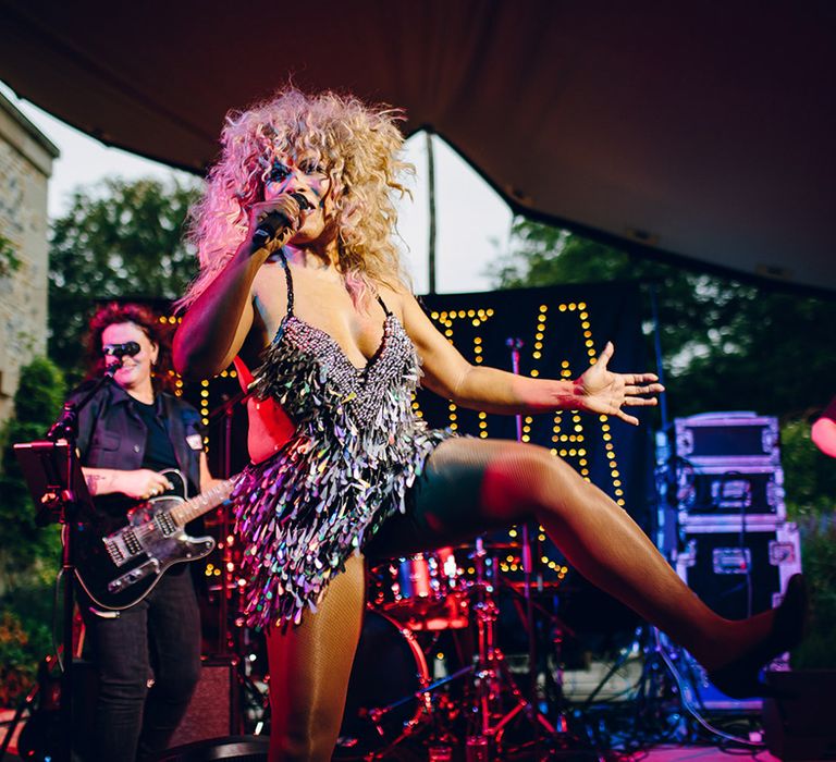 Singer on stage dancing wearing v neck fringed sequin party dress 