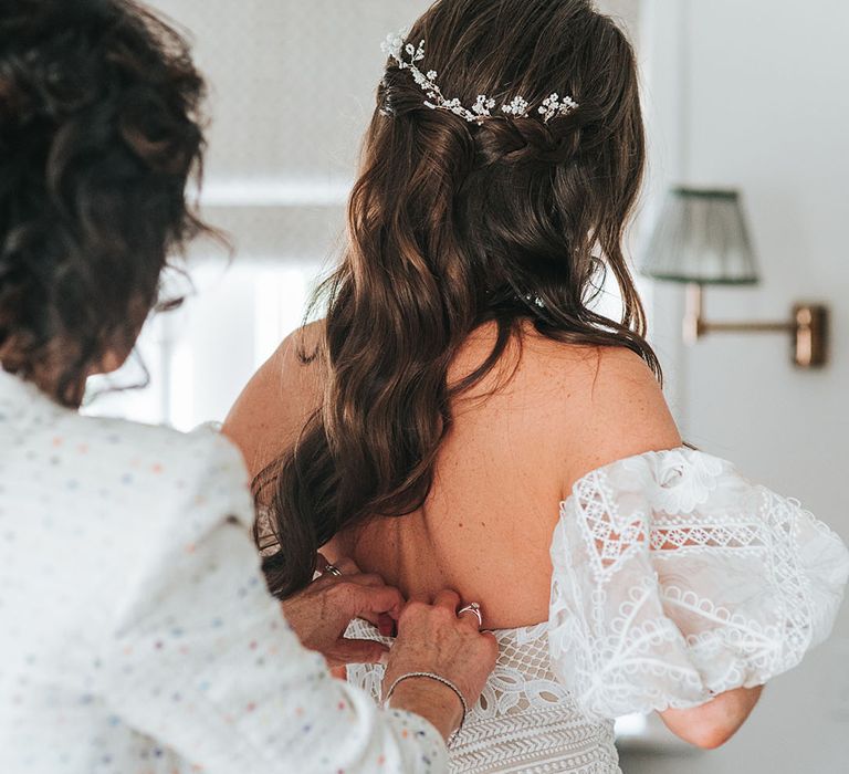 Bride with brown hair in a half up half down hairstyle with white flower accessory 