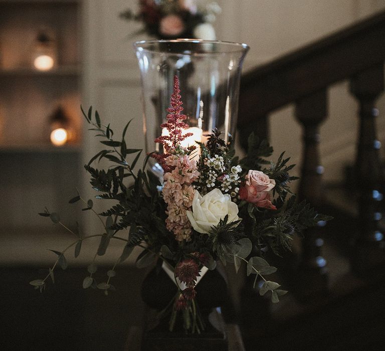 Pink roses and stock with white wax flower, and roses around the lanterns on the stairs 