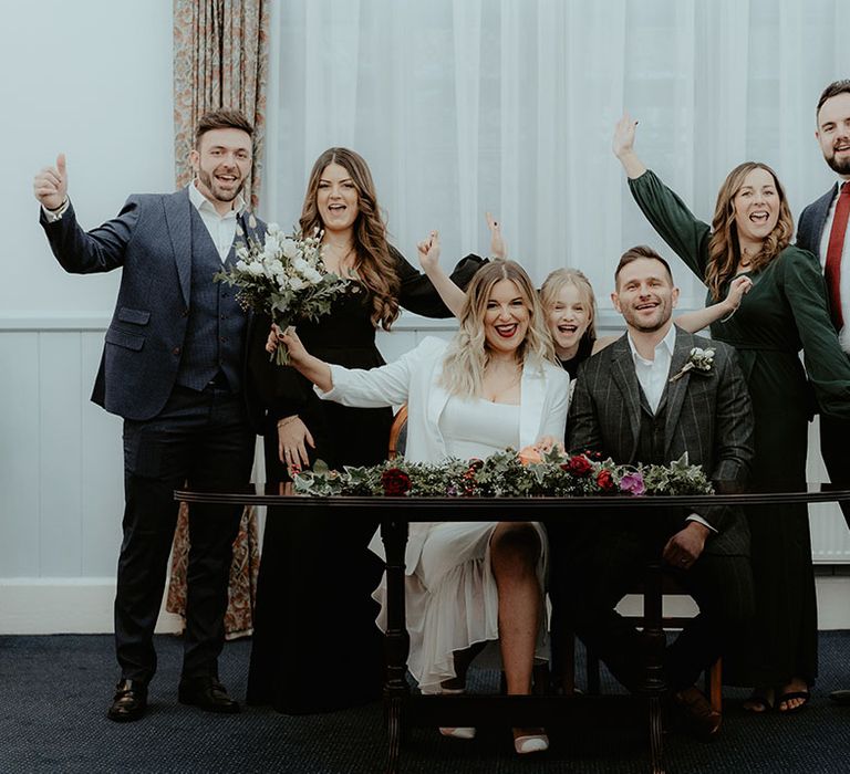 Micro wedding at Stroud Registry Office celebrate together as the bride and groom sign the register to be officially husband and wife 