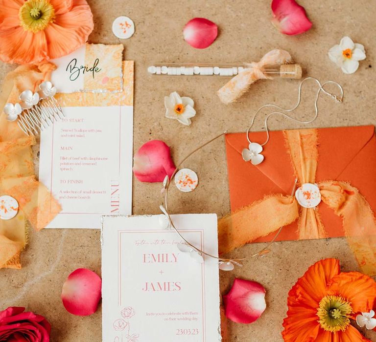 Orange, pink, white and red wedding stationery with frayed ribbon, orange Iceland poppies, dainty silver bridal jewellery and wedding menus 