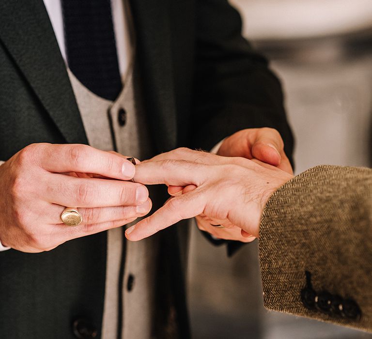 The groom slides on the wedding ring as part of the wedding ceremony tradition