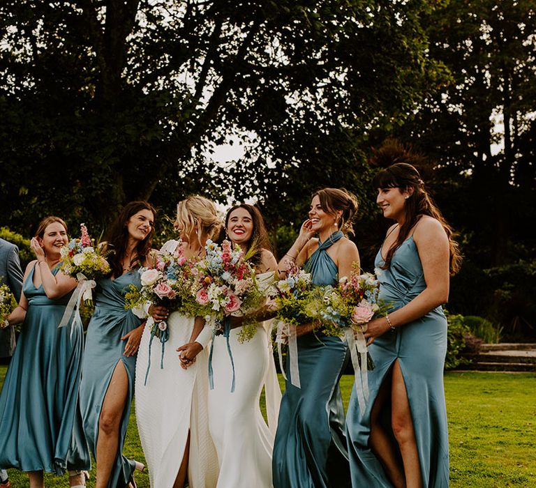 Wedding party wearing blue bridesmaid dresses and a bridesman wearing a blue suit 