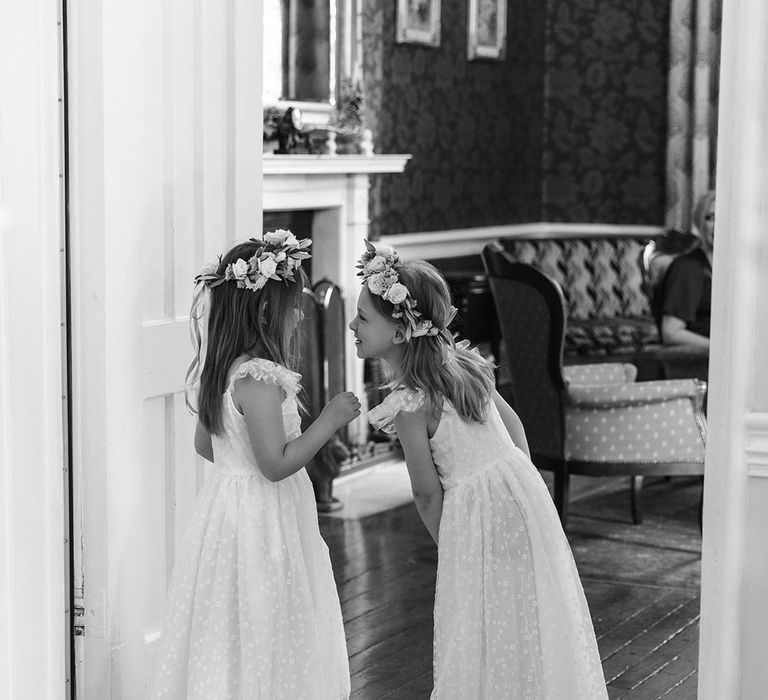 Two flower girls wearing white dresses for the wedding 