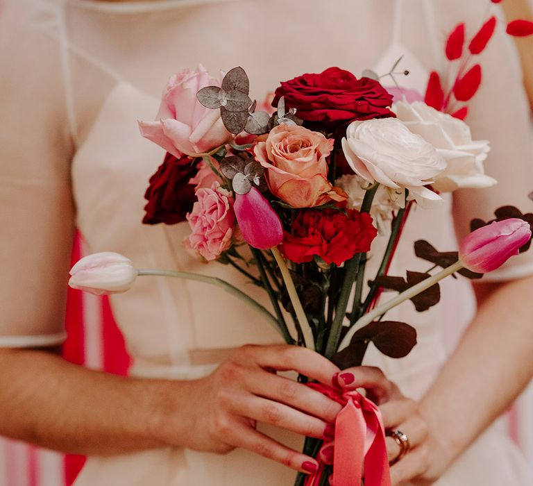 Bride holding Valentine's inspired wedding bouquet with roses and tulips 