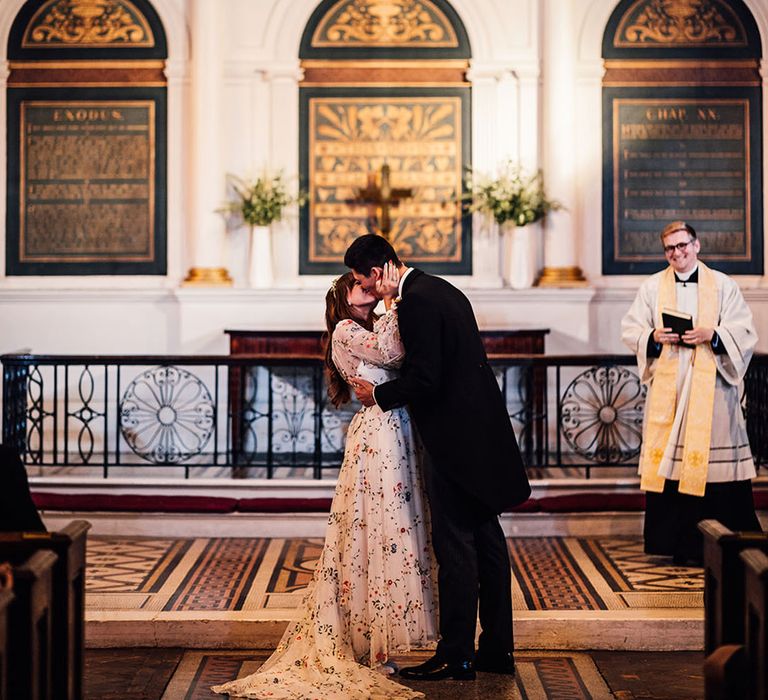 Traditional church wedding ceremony with bride and groom sharing their first kiss as a married couple 