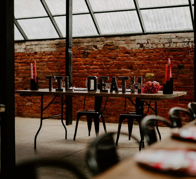 Sweetheart table for the bride and groom decorated with red and pink theme at industrial wedding venue 