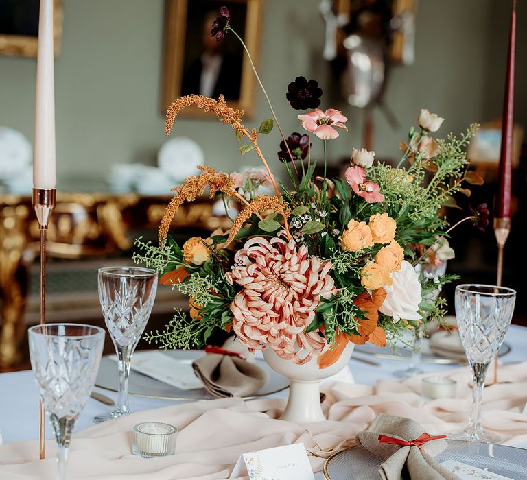 Colourful wedding flower table decorations in autumnal tones 