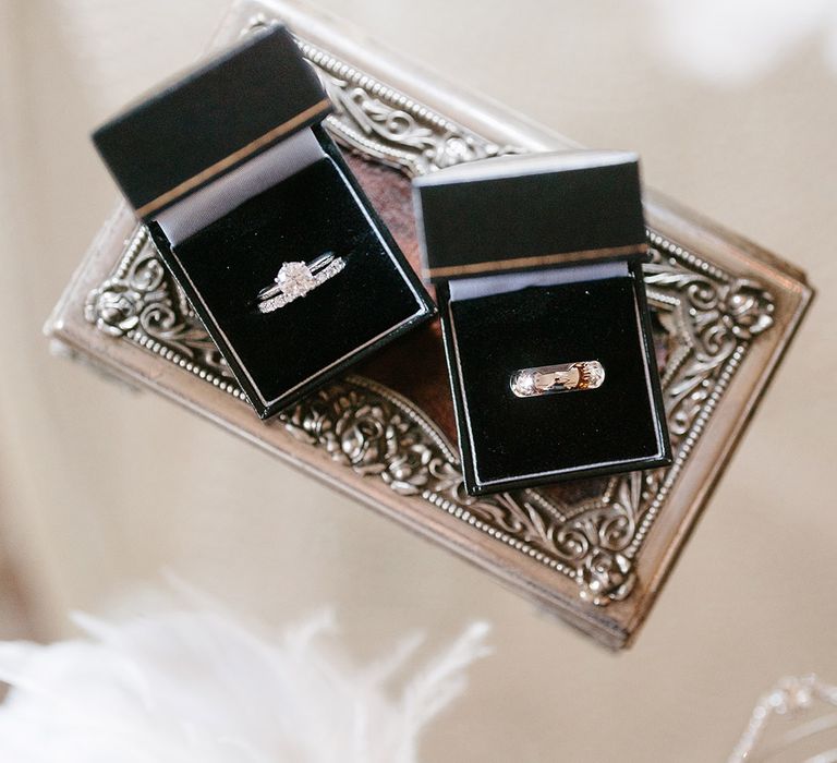 Wedding ring boxes with the groom's wedding band and bride's diamond wedding band and round brilliant diamond engagement ring 