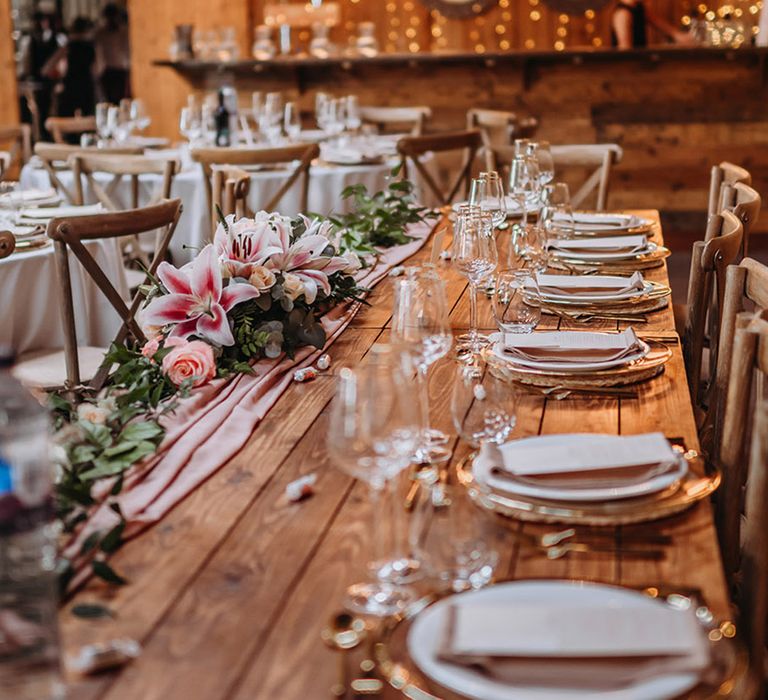 Chafford Park rustic wedding venue decorated pink table centrepieces with pink lilies and tablecloth with fairy lights 