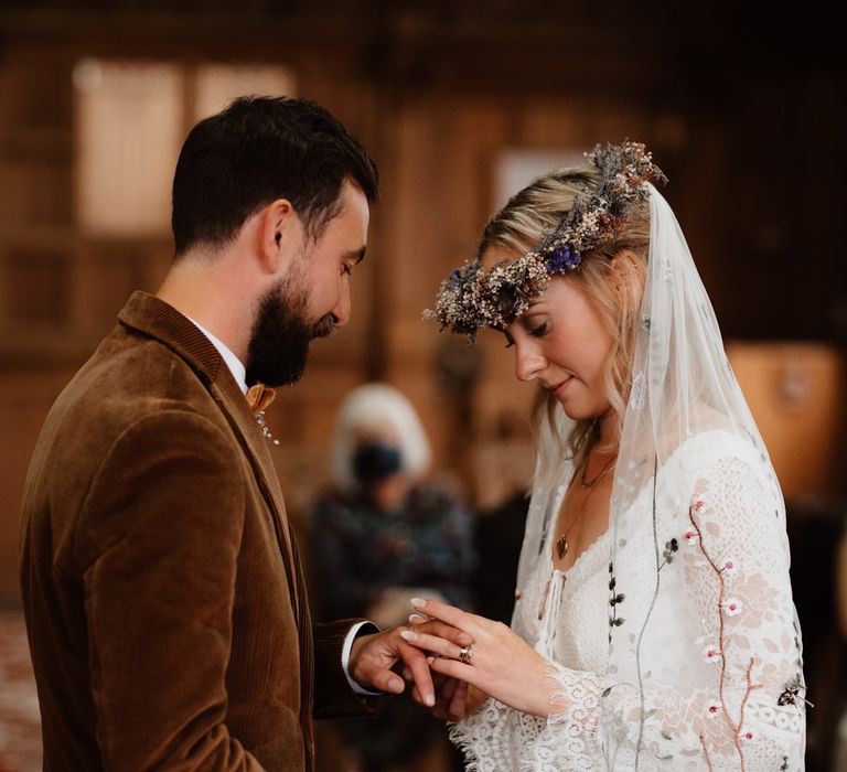 Groom putting on his brides wedding ring 