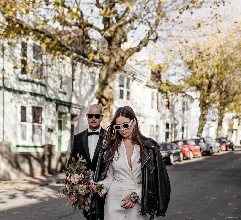 Alternative bride and groom walking through the Brighton streets at stylish micro wedding 