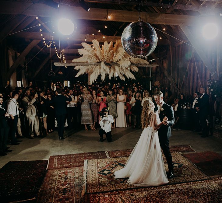 First dance in a barn decorated with rustic wedding decor 