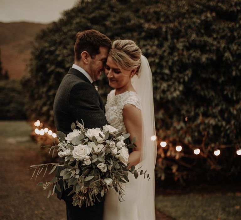 Couple on the wedding day with sparkly lights for picturesque Lake District wedding