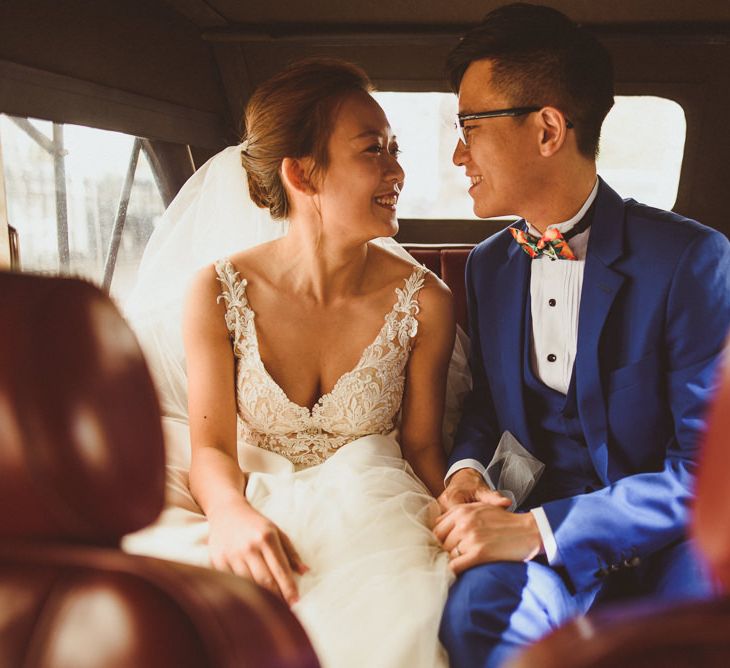 Bride and groom sitting in the back of their vintage wedding car 