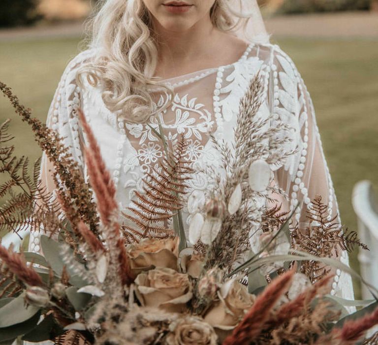 The Bride looks down at her pampas grass bouquet