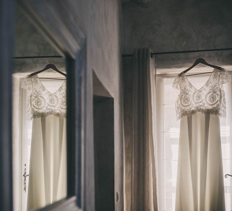 The bride's Laure de Sagazan wedding dress hangs in the window