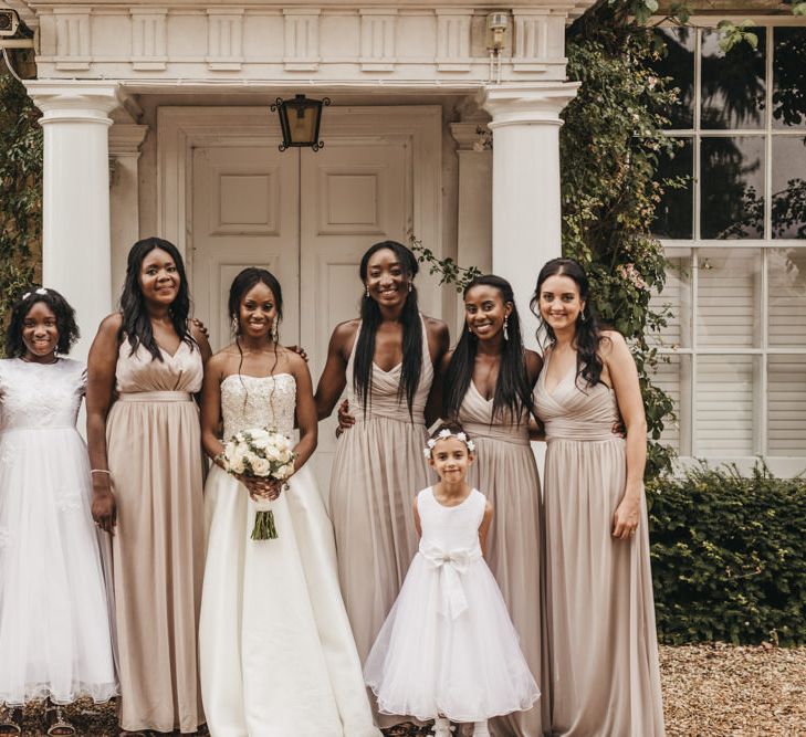 Bridal party portrait with Black bride in a Oleg Cassini wedding dress, Junior bridesmaid and flower girl in a white dresses, and Bridesmaids in dusky pink chiffon dresses