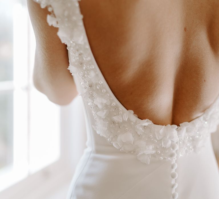 Low back wedding dress with appliqué and diamanté detail and buttons