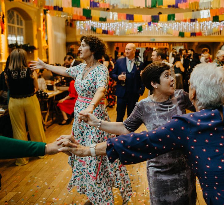 Wedding guests in floral dresses dancing at DIY wedding 