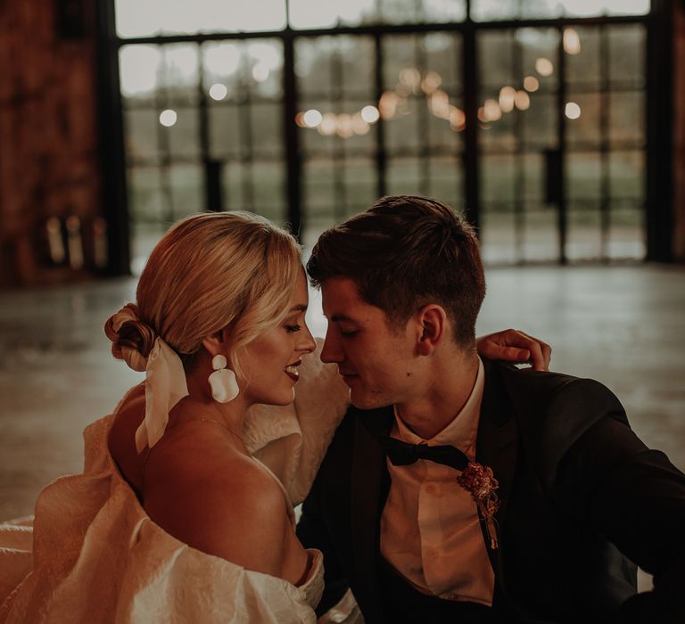 Bride in Muted Luxe earrings and sleek bridal bun wedding hairstyle 