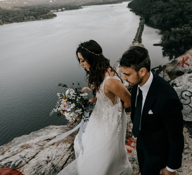 Bride & groom walk together near the Hudson River