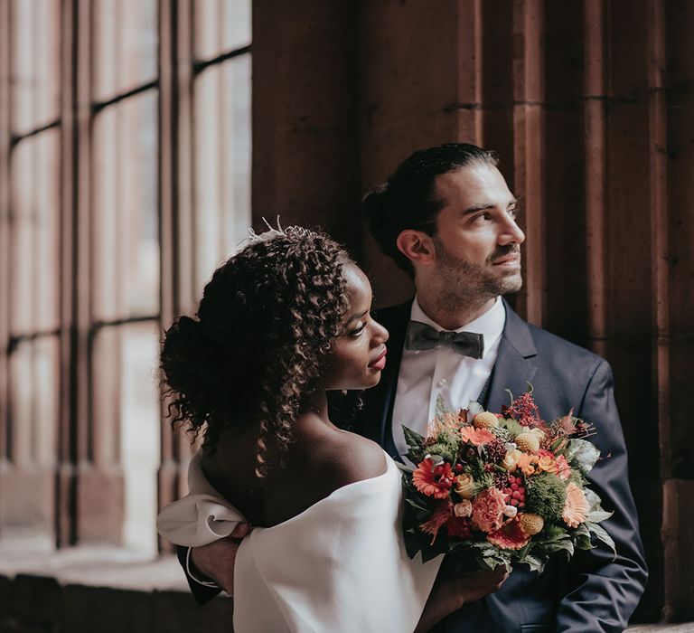 Bride & groom look out the window together after wedding ceremony