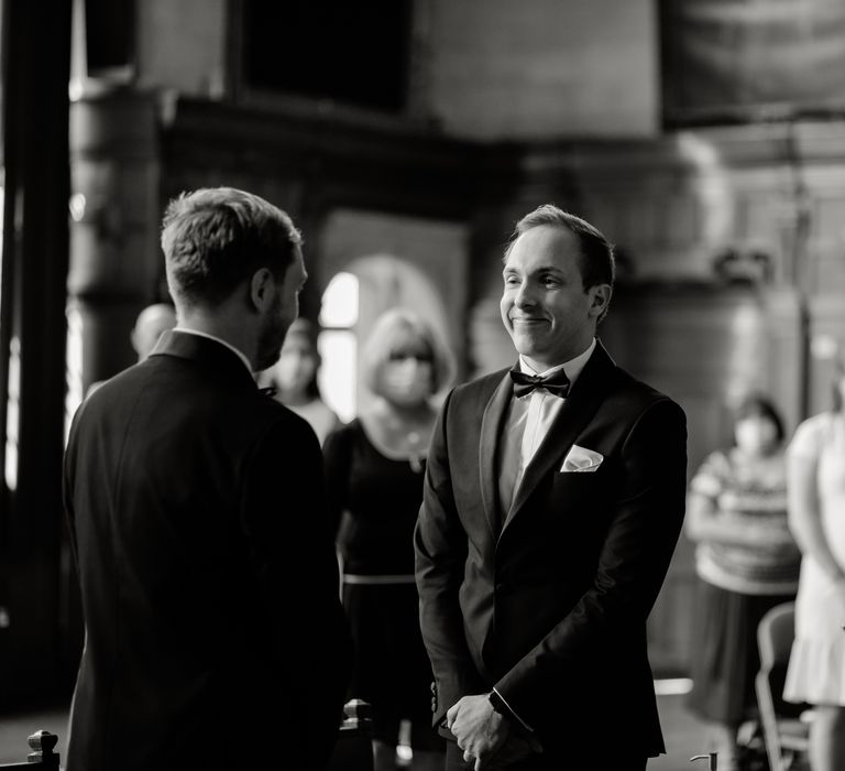 Grooms during wedding ceremony in black & white image