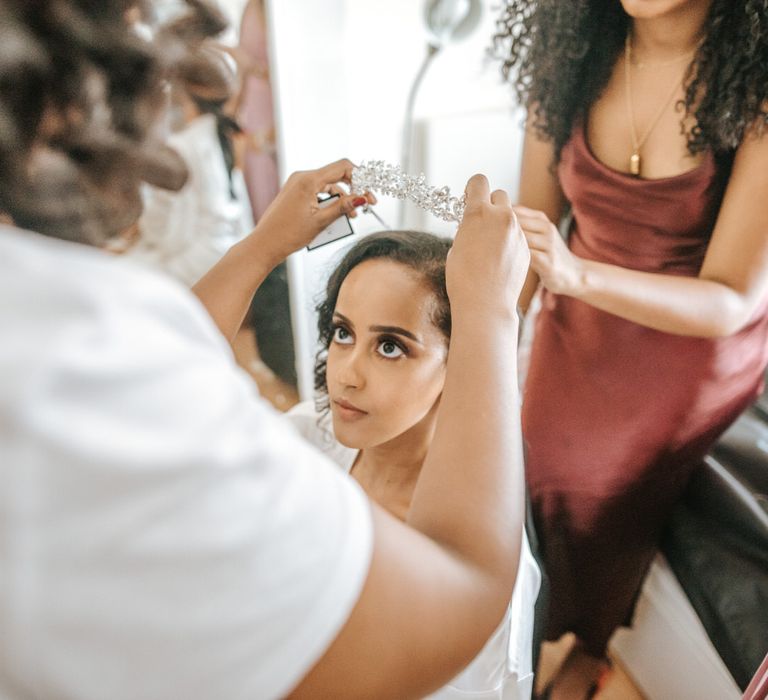 Wedding morning bridal preparations with bride putting on her tiara