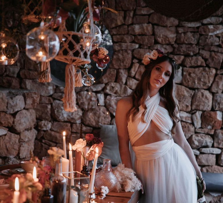 Bride wearing adjustable strap tulle wedding gown with cut out detail by a candlelit tablescape