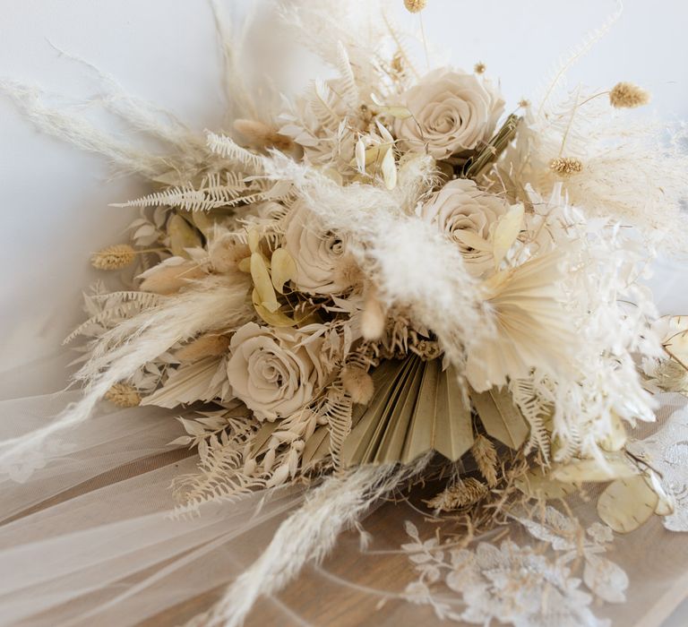 Beige dried flower wedding bouquet with pampas grass, palm leaves and roses 